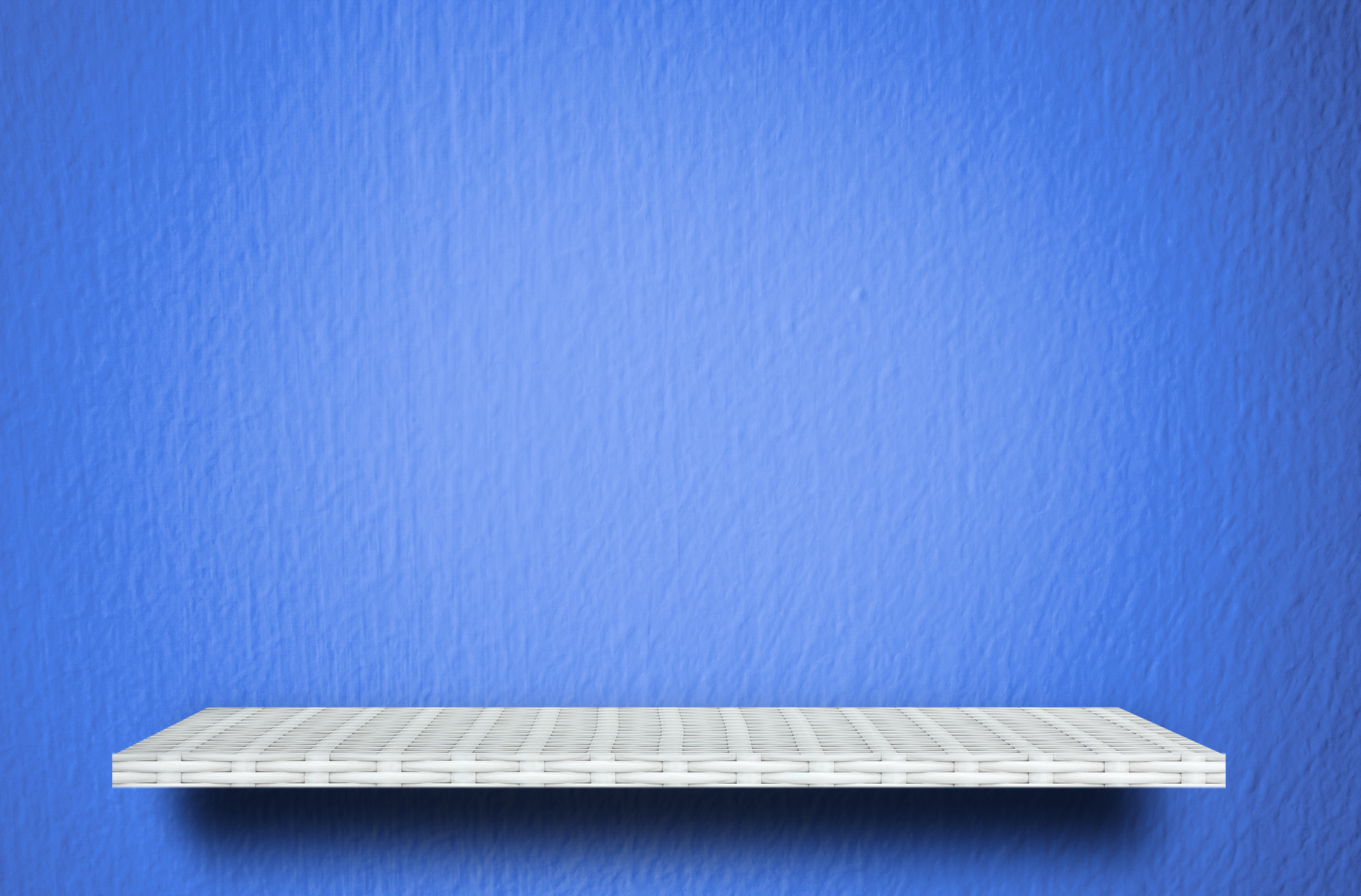 Empty white shelf on blue cement background for product display